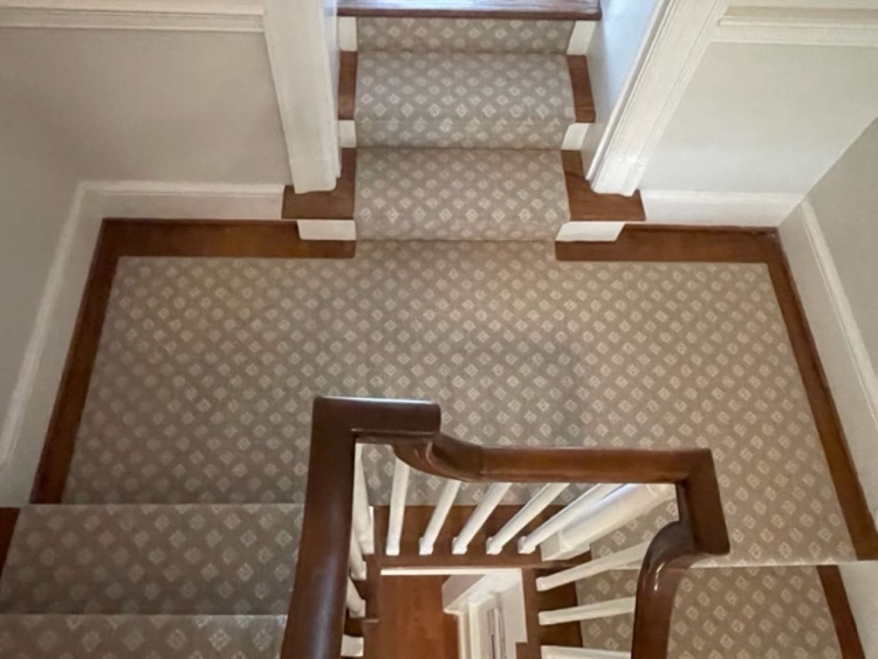 creaa and tan stair runner on wood flooring